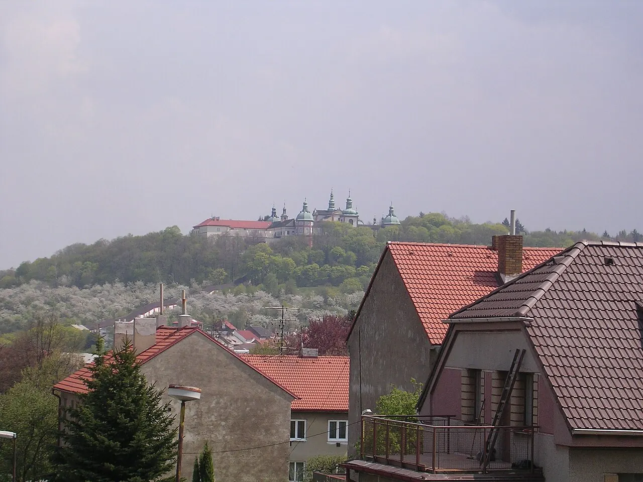 Pohled přes střechy domů na Svatou Horu nad Příbramí